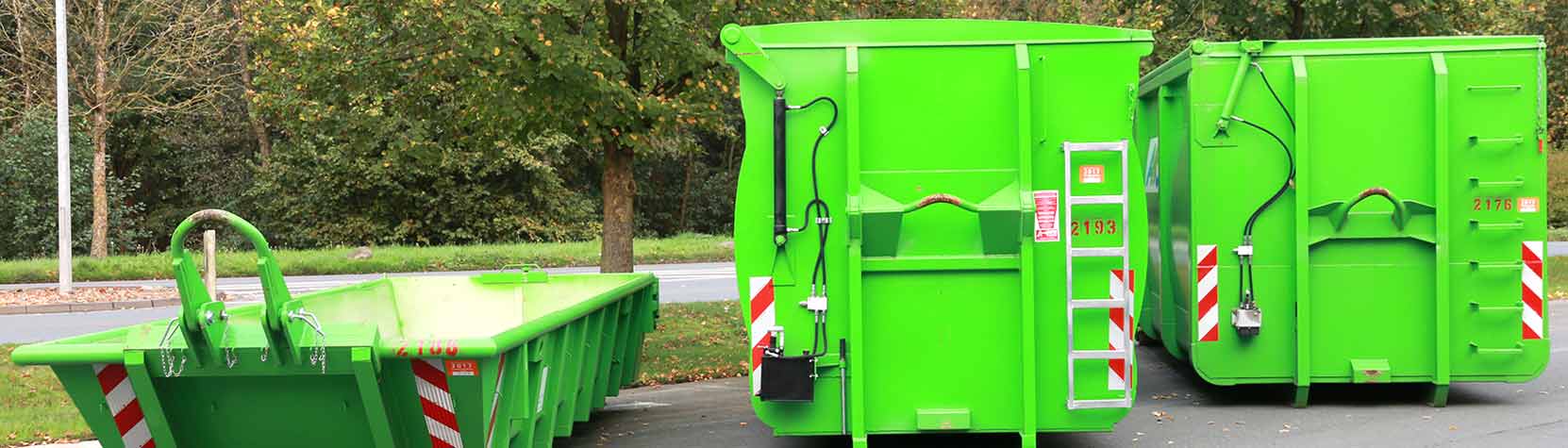 drei verschieden große Container stehen am Straßenrand